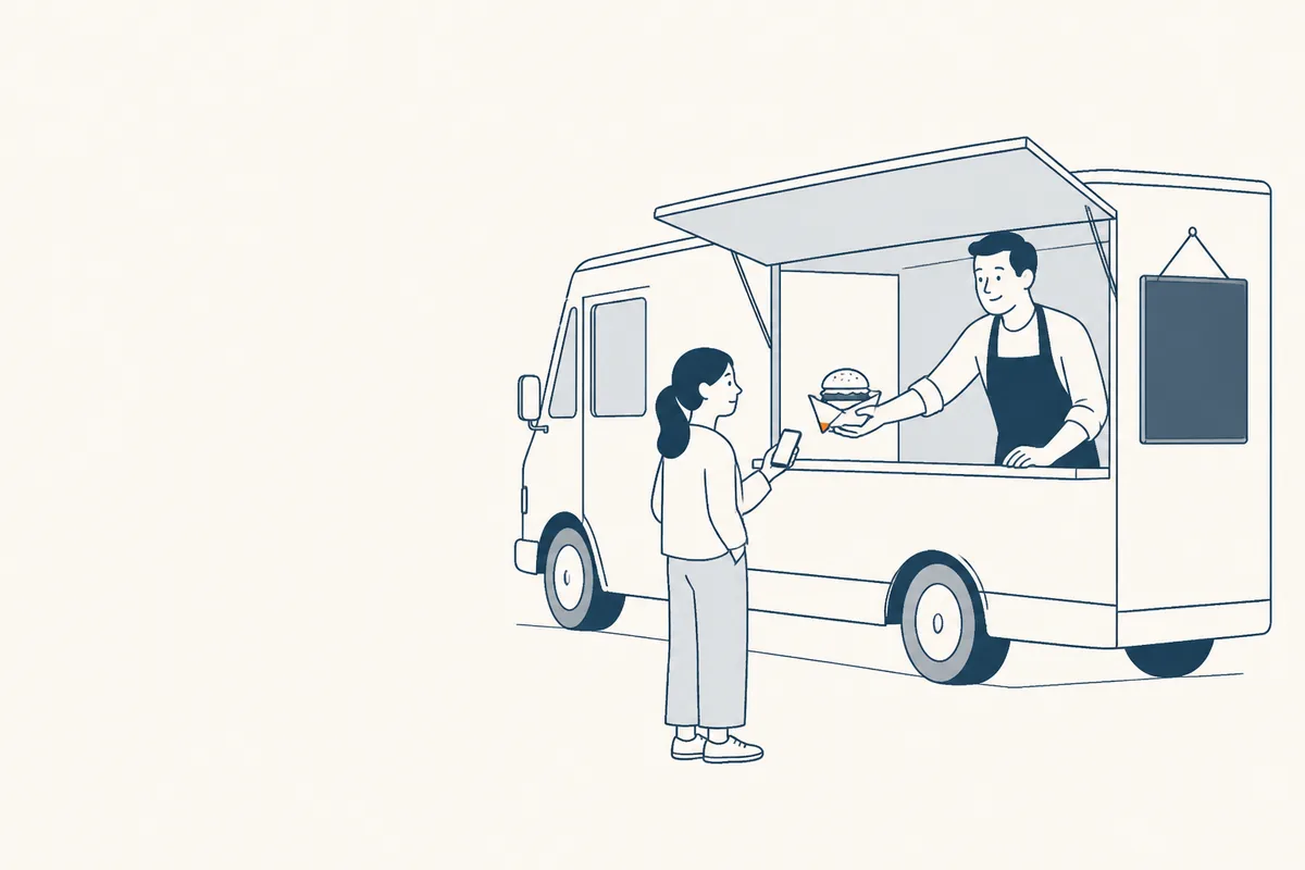 Un food truck ouvert, un cuisinier tend un burger à une cliente qui tient son téléphone.